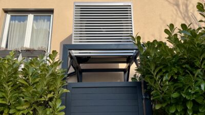 Wärmepumpe, die erhöht aufgeständert an ein Gebäude montiert wurde