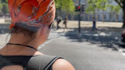 Person wartet geduldig an roter Ampel.