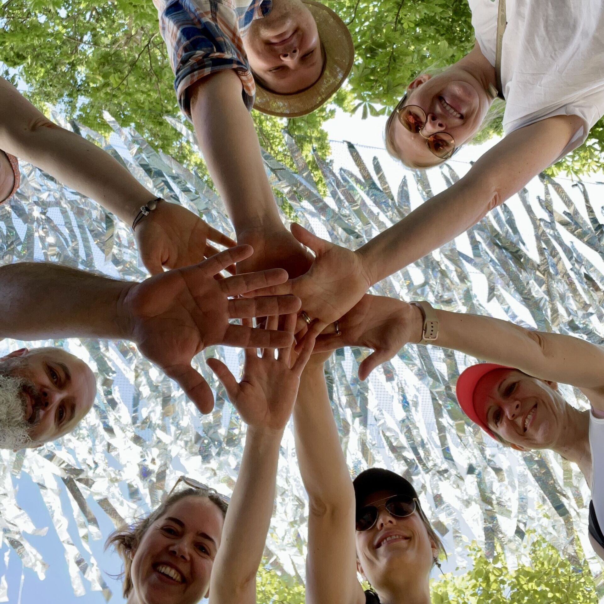 Teammitglieder der LEA führen ihre Hände im Zeichen des Teamspirit zusammen.